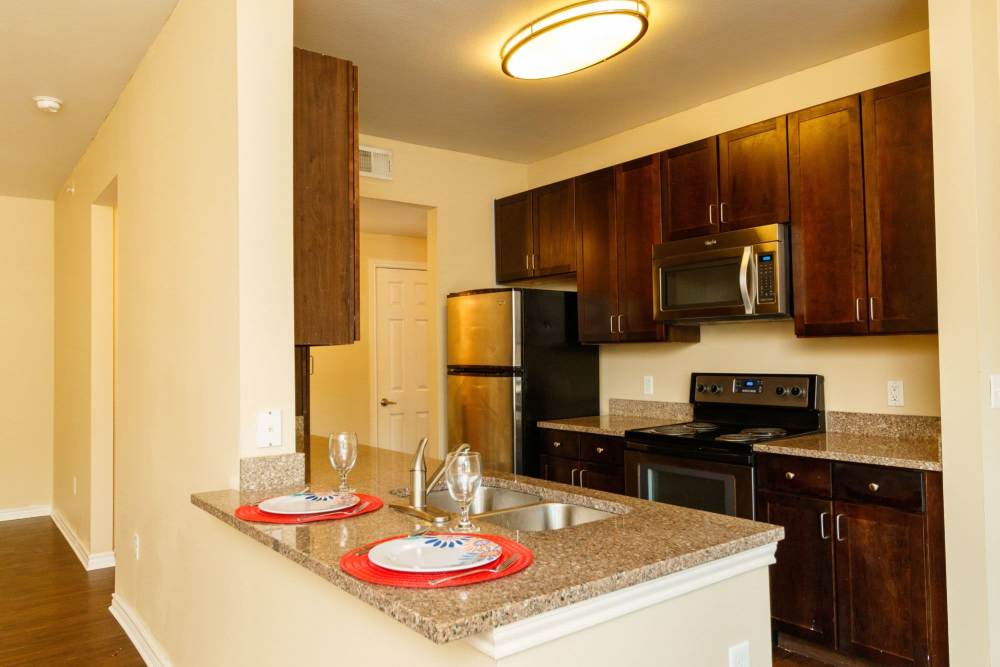 Kitchen island with waterfall faucet, and granite countertops at North Court Villas in Frisco, Texas