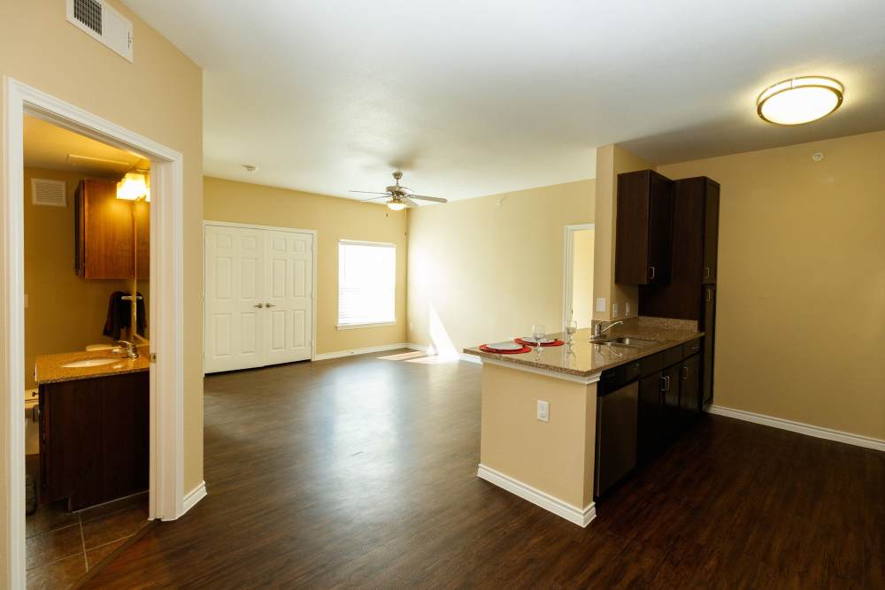 Open layout of kitchen and living room with bar counter at North Court Villas in Frisco, Texas